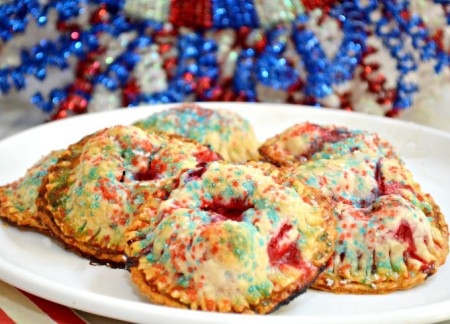 Refrigerated pie crust makes it easy to whip up a batch of grab-and-go Raspberry Hand Tarts! Jazz them up for the 4th with red, white & blue sanding sugar. Fun & easy! Recipe at littlemisscelebration.com
