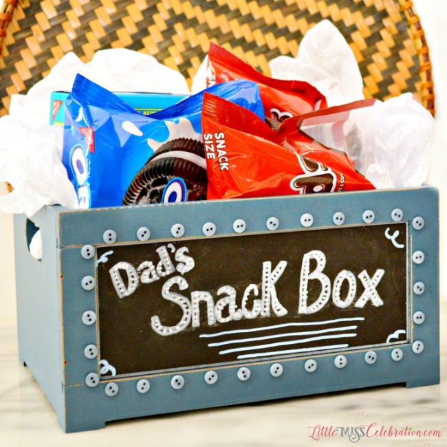 A small wooden crate that’s pre-painted with a chalkboard front makes it a snap to put together this Easy Snack Crate for Dad! Fill with his favorite munchies! at littlemisscelebration.com